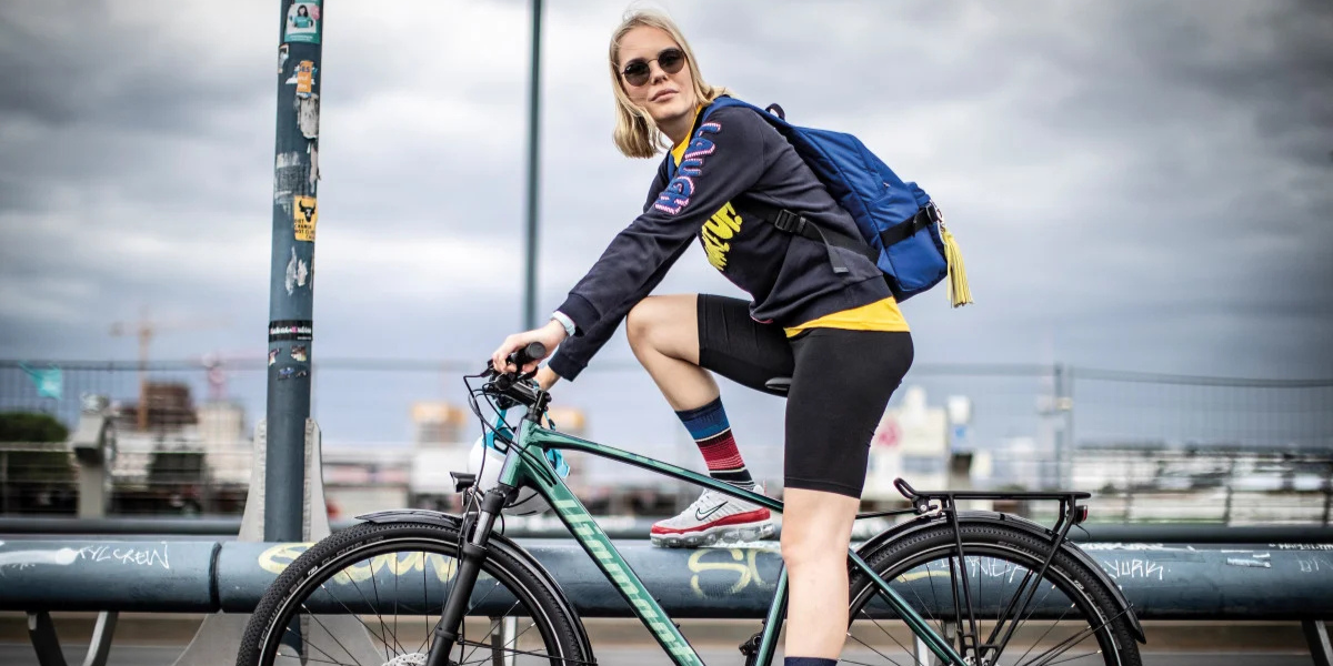 blonde Frau mit Sonnenbrille sitzt auf Diamand Fahrrad