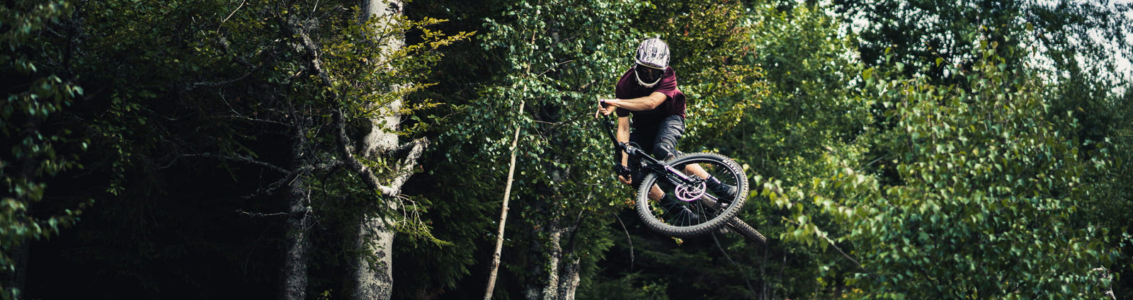 Biker in Österreich im Bikepark springt über Hindernis